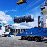 Heavy project cargo unit transferred by crane onto trailer for onward transport from port