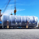 Heavy project cargo unit on trailer during crane handling at port terminal