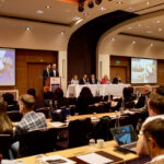 Conference audience attending a project logistics presentation featuring Hacklin Shanghai case examples and international heavy-lift transportation solutions.