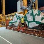 Night-time cargo operations at the Port of Helsinki with oversized industrial equipment prepared and secured for overseas transportation.