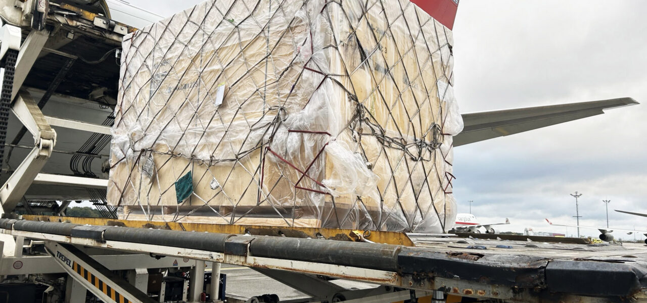Crated industrial equipment secured on an air cargo platform before departure from Finland to Japan.